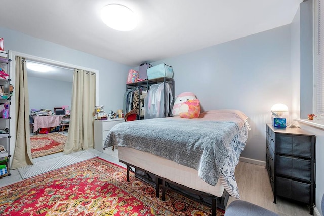 bedroom with light wood-style flooring and baseboards