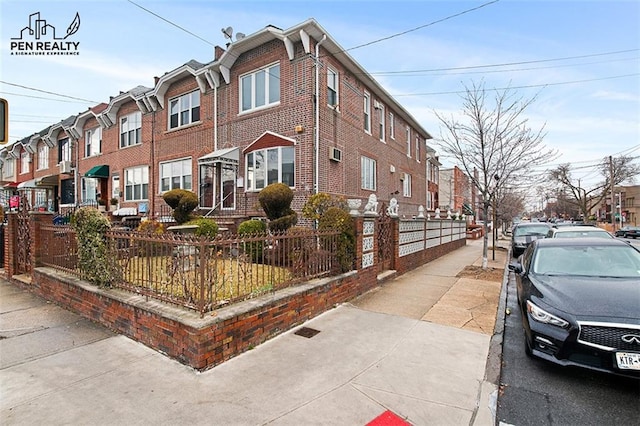 view of front of house featuring a fenced front yard, a residential view, and brick siding