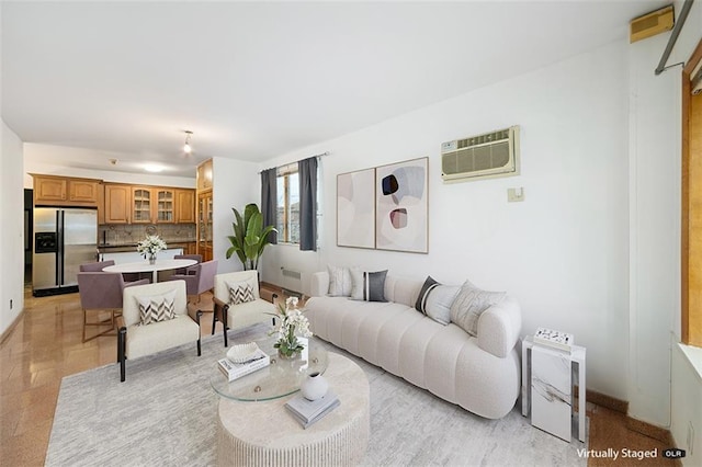 living area with baseboards and a wall unit AC