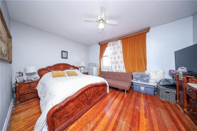 bedroom with baseboards, a ceiling fan, and wood finished floors