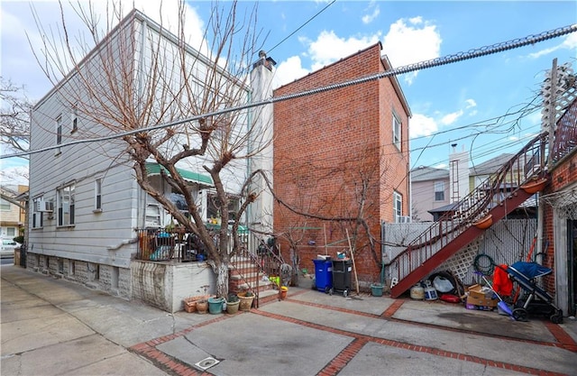 view of side of property featuring a chimney and stairs