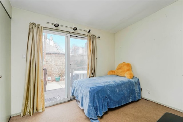 bedroom featuring baseboards, carpet, and access to outside