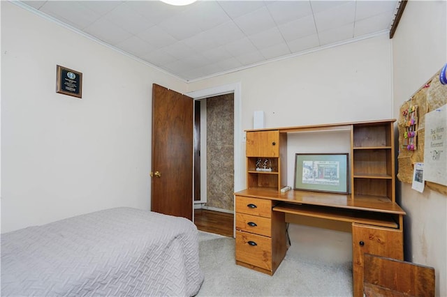 bedroom featuring ornamental molding and built in desk