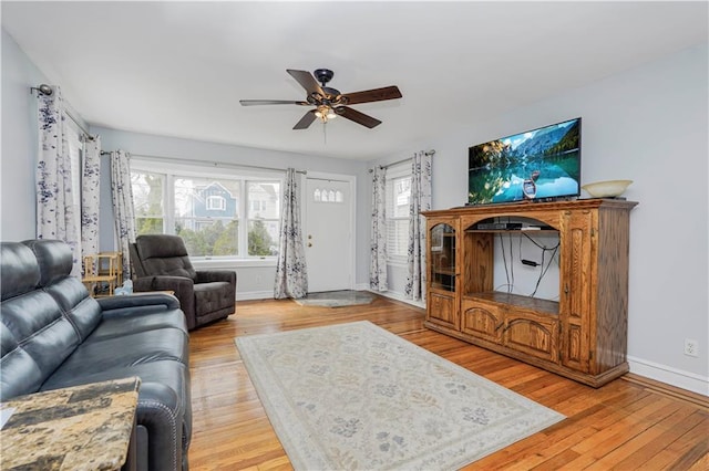 living room with plenty of natural light, light wood-style flooring, and a ceiling fan