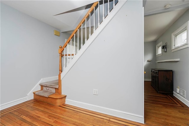 stairway featuring baseboards and wood finished floors