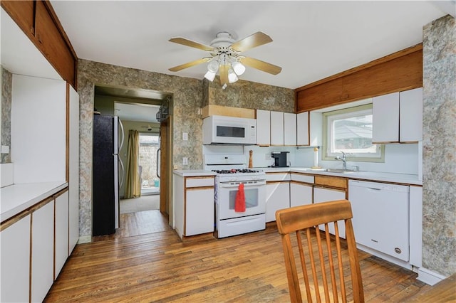 kitchen featuring light wood-style flooring, white appliances, white cabinetry, and light countertops