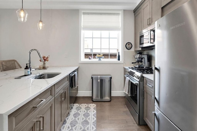 97 Battery Ave Unit 3B, Brooklyn, NY 11209 - kitchen featuring appliances with stainless steel finishes, a sink, wood finished floors, baseboards, and light stone counters