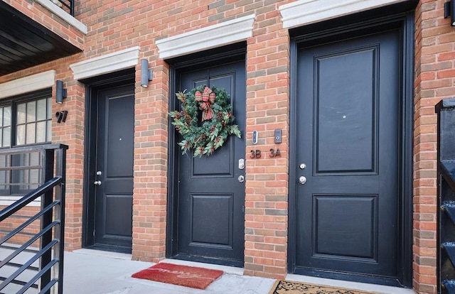 doorway to property with a porch and brick siding