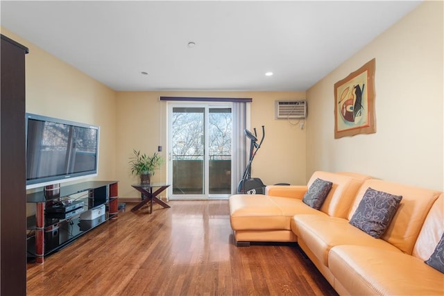 living area with recessed lighting, wood finished floors, and a wall mounted air conditioner