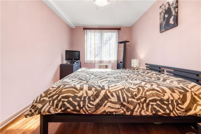 bedroom with wood finished floors and baseboards