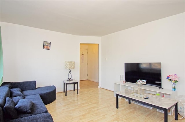 living area featuring baseboards and wood finished floors