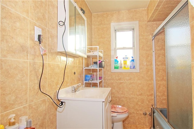 full bath with toilet, shower / bath combination with glass door, tile walls, and vanity