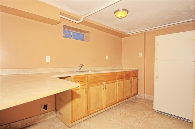 kitchen featuring freestanding refrigerator, light countertops, and light tile patterned flooring