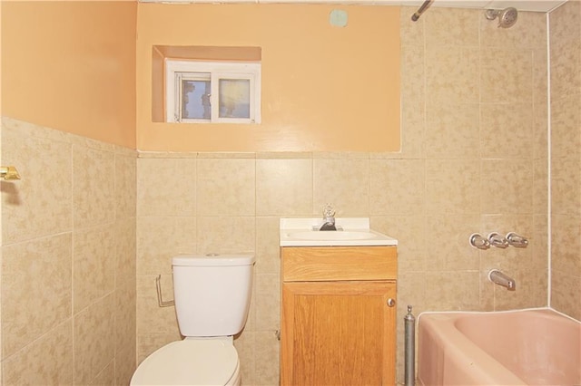 bathroom featuring toilet, bathing tub / shower combination, vanity, and tile walls