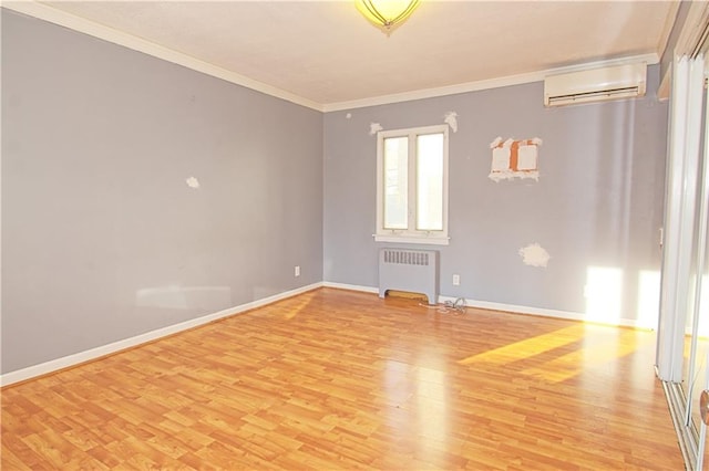empty room with crown molding, light wood-style flooring, radiator, and a wall mounted air conditioner