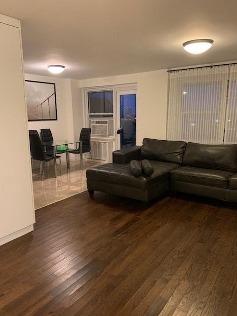 living room with cooling unit and wood finished floors