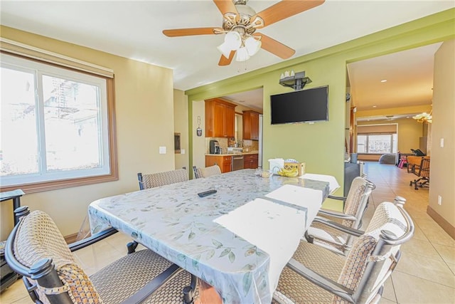 dining area featuring light tile patterned flooring, ceiling fan, and baseboards