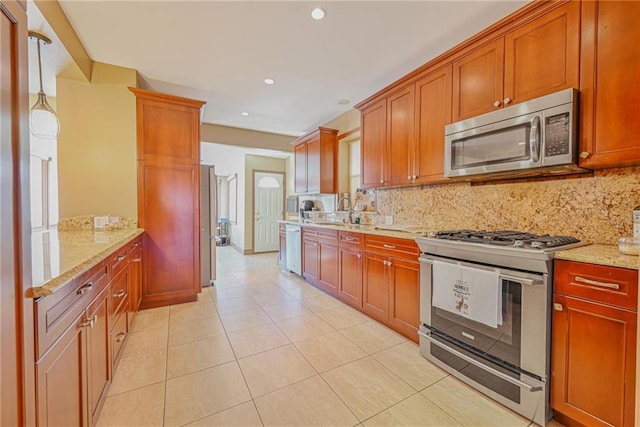 kitchen with stainless steel appliances, decorative backsplash, light stone countertops, recessed lighting, and light tile patterned floors