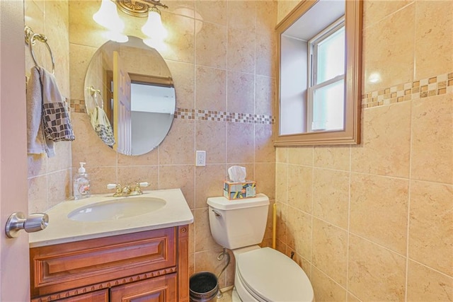half bathroom featuring vanity, toilet, and tile walls