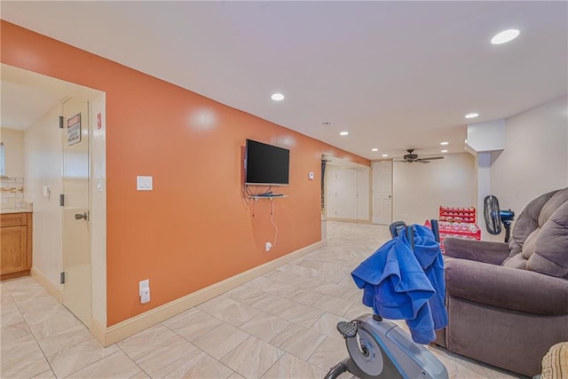 living area featuring ceiling fan, light marble finish floors, recessed lighting, and baseboards