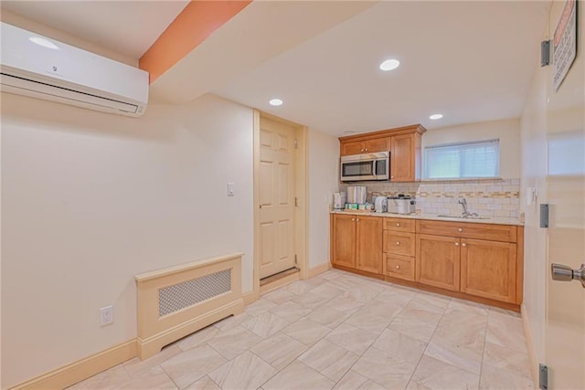 kitchen with stainless steel microwave, a wall unit AC, light countertops, a sink, and recessed lighting
