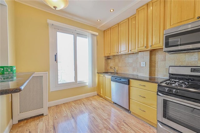 kitchen with stainless steel appliances, baseboards, healthy amount of natural light, decorative backsplash, and ornamental molding