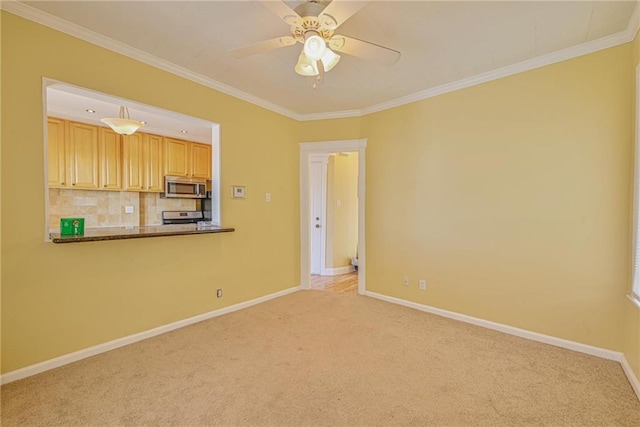 unfurnished living room featuring carpet flooring, a ceiling fan, ornamental molding, and baseboards