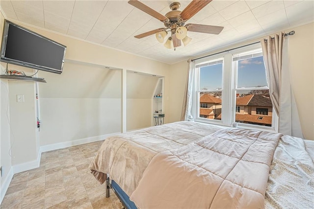 bedroom featuring baseboards, crown molding, and ceiling fan