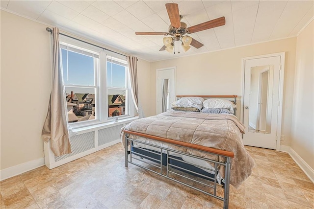 bedroom featuring crown molding, stone finish flooring, baseboards, and a ceiling fan