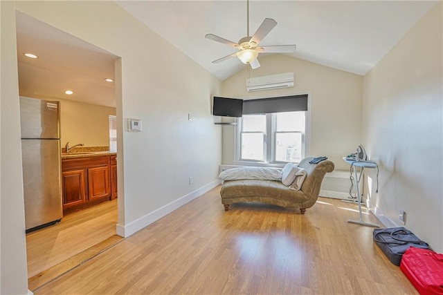 sitting room featuring an AC wall unit, ceiling fan, light wood-type flooring, lofted ceiling, and baseboards