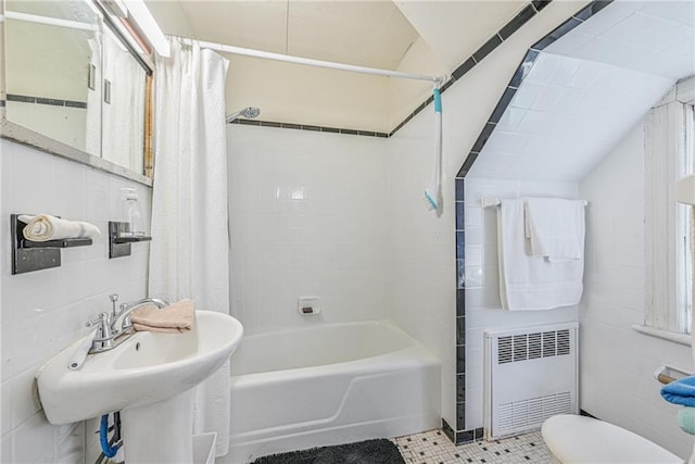 full bath featuring radiator, tile walls, a sink, toilet, and shower / tub combo with curtain
