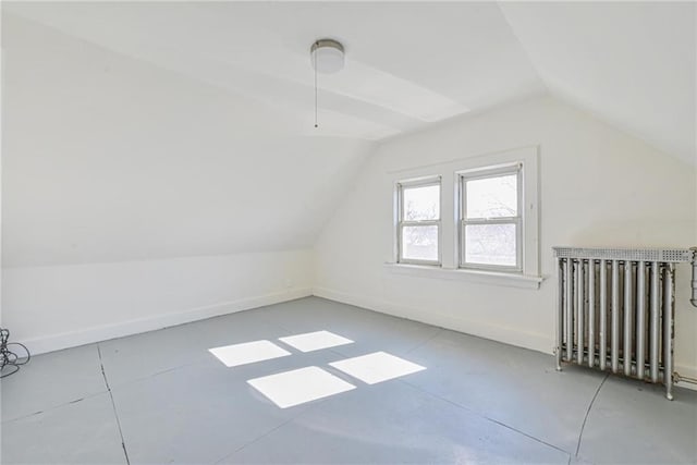 bonus room featuring lofted ceiling, baseboards, and radiator