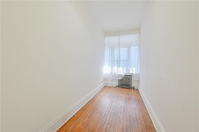 spare room featuring baseboards and light wood-style flooring