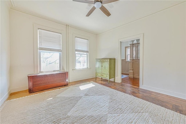 spare room with wood finished floors, plenty of natural light, a ceiling fan, and baseboards