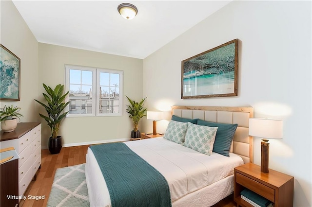 bedroom featuring wood finished floors and baseboards