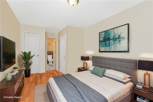 bedroom featuring light wood-style floors and ensuite bathroom