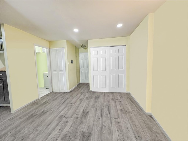 interior space with recessed lighting, baseboards, light wood-type flooring, and connected bathroom