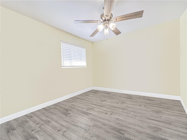 unfurnished room with wood finished floors, baseboards, and ceiling fan