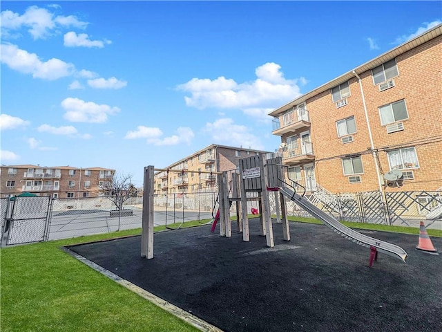 communal playground featuring a residential view, a yard, and fence