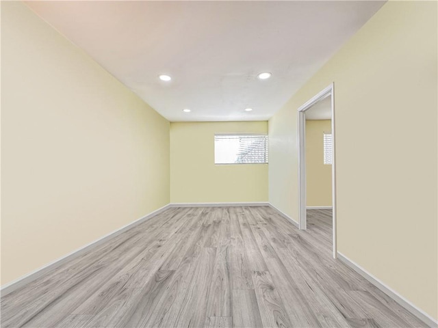 spare room featuring recessed lighting, light wood-style floors, and baseboards