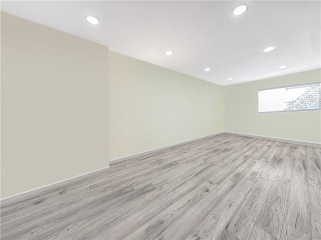 unfurnished room featuring recessed lighting, light wood-type flooring, and baseboards