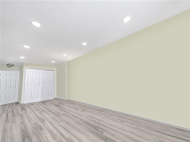 empty room featuring recessed lighting, light wood-type flooring, and baseboards