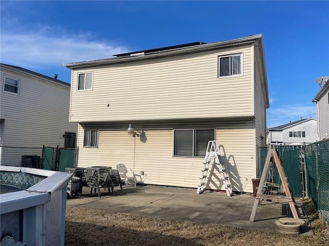 back of property with a patio area and fence