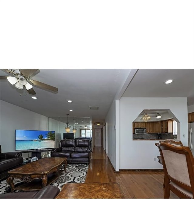 living room featuring recessed lighting, wood finished floors, arched walkways, and ceiling fan