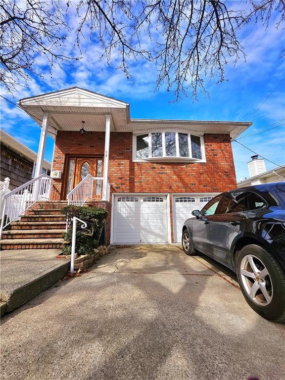 view of front of property with driveway, brick siding, and an attached garage