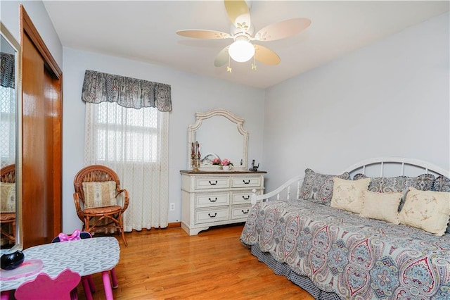 bedroom featuring ceiling fan, light wood finished floors, and baseboards