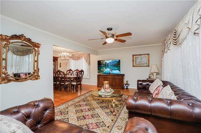 living area featuring ceiling fan with notable chandelier, crown molding, baseboards, and wood finished floors