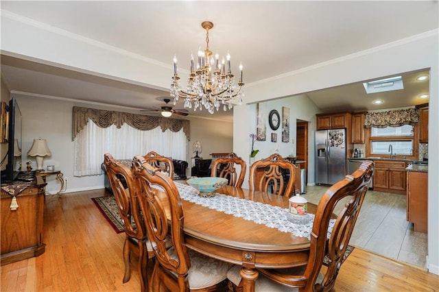 dining space featuring ceiling fan with notable chandelier, ornamental molding, light wood-style flooring, and baseboards