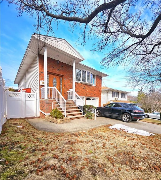 view of front facade with a garage, concrete driveway, brick siding, and fence