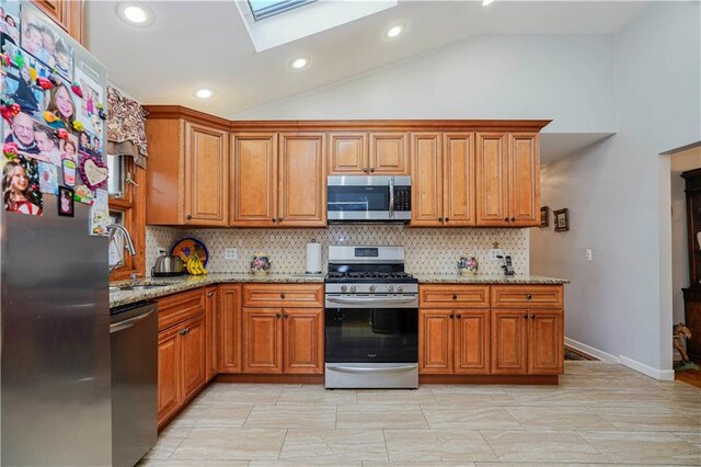 kitchen with appliances with stainless steel finishes, brown cabinets, and a sink